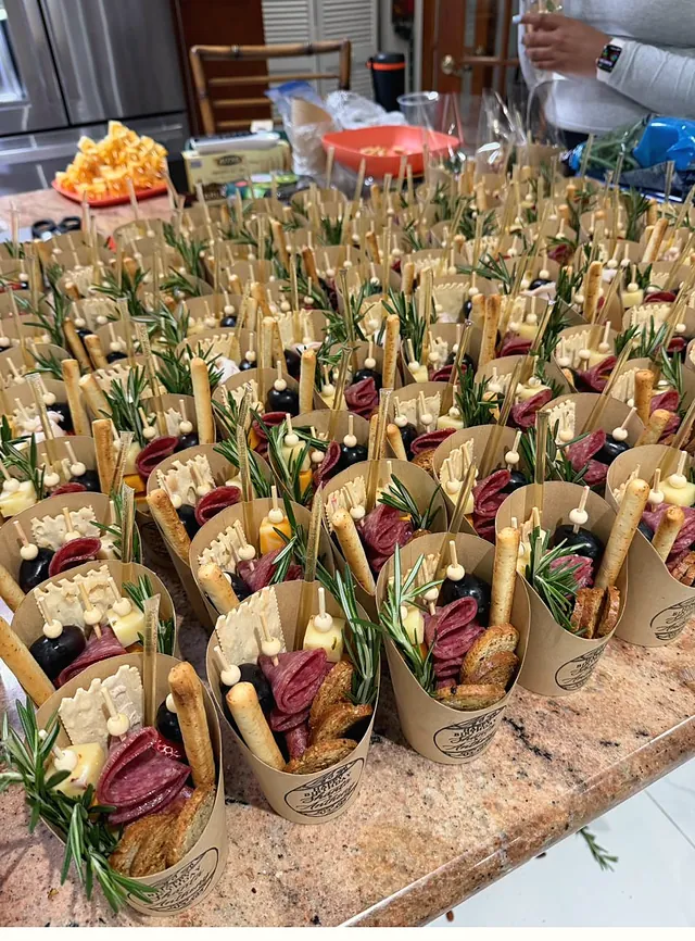 Rows of Onboard charcuterie cups, each wrapped and ready for a guest