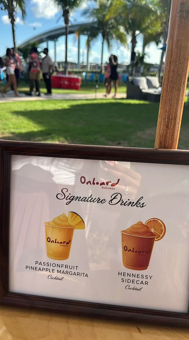 A framed Onboard signature drinks menu at an outdoor event